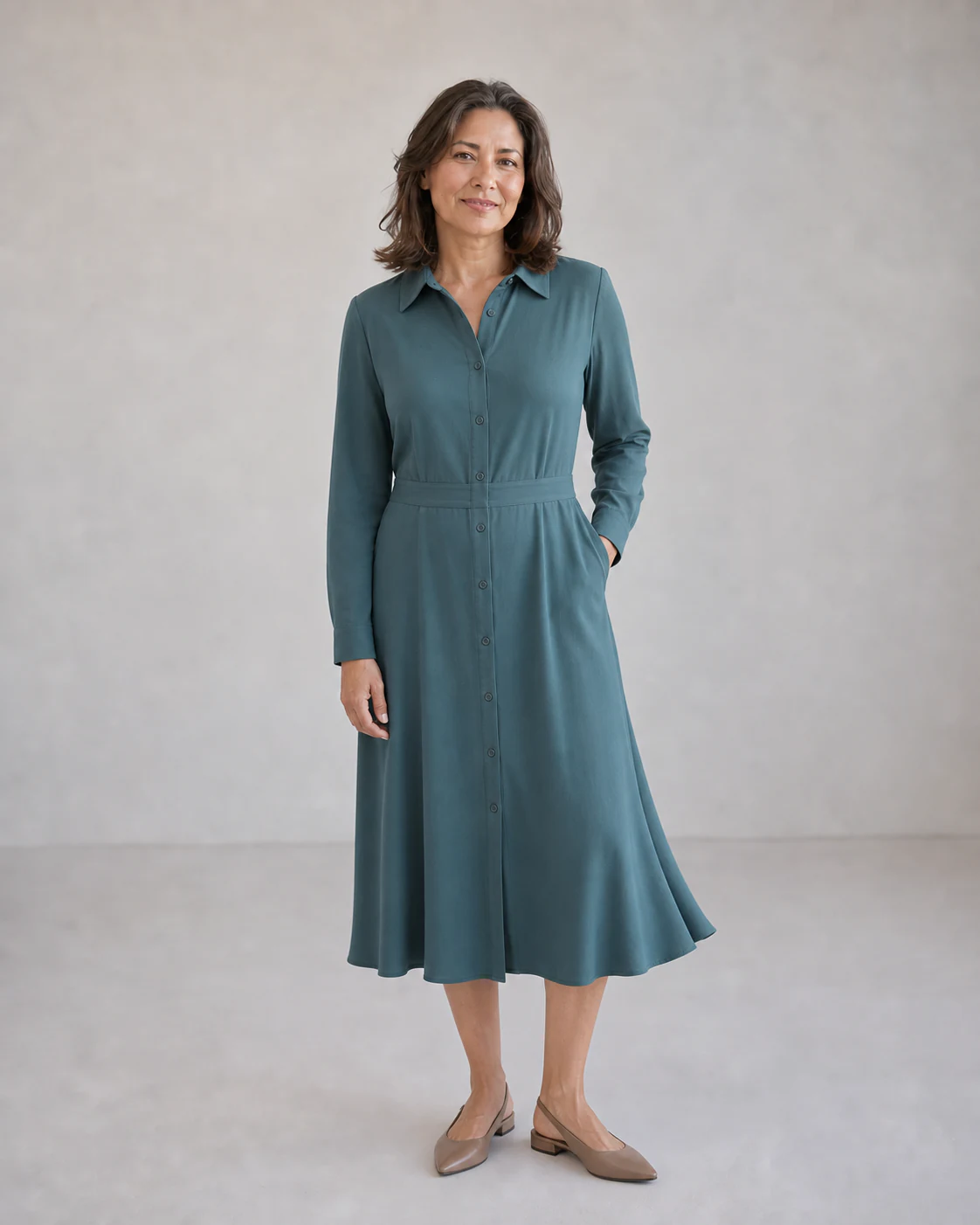 The same fictional 48-year-old model in a fresh muted teal midi shirt dress and taupe slingbacks