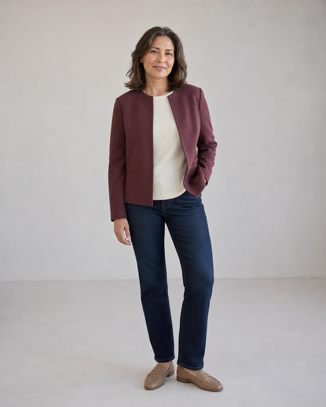 Fictional pre-generated representative full look with a muted berry jacket, warm ivory knit, dark indigo jeans, and taupe loafers for Modern Soft Structure
